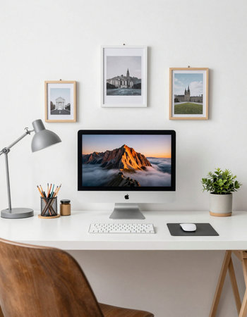 Computer with mountains on the screen on a white table in a home office
