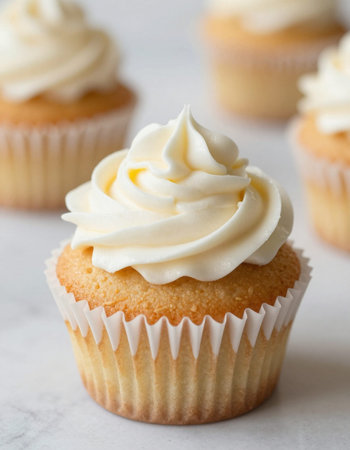 Vanilla cupcakes with buttercream frosting on a white backgroundの写真素材