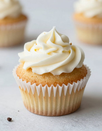 Vanilla cupcake with buttercream frosting on a white backgroundの写真素材
