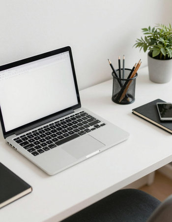 Cropped image of modern workplace with blank screen laptop, smartphone and stationery on white table