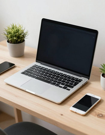 Laptop and mobile phone on wooden desk in office. Work from home concept.の写真素材