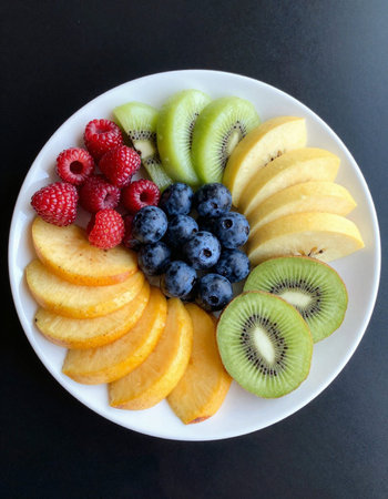 Fruit salad with kiwi, peach, blueberry and raspberry