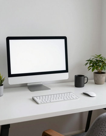 Modern workplace with blank screen computer, keyboard, mouse and coffee cup on white tableの写真素材