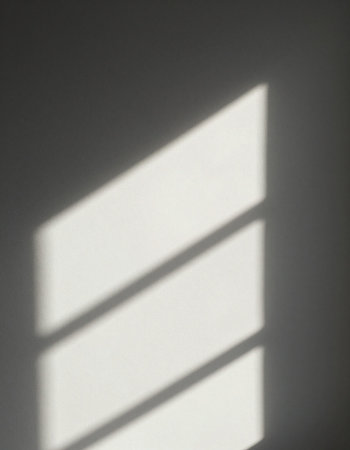 Shadow of a window on a white wall with a shadow from the sunの写真素材