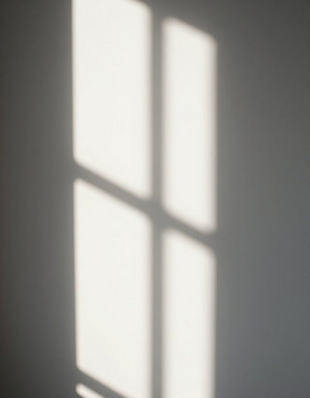 Shadow of a window on a white wall. Sunlight and shadows.