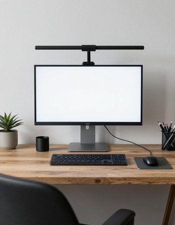 Front view of modern workspace with blank white computer screen, keyboard, coffee cup and other items. Mock upの写真素材
