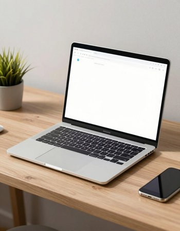 Laptop with blank screen on wooden table in office room, stock photo