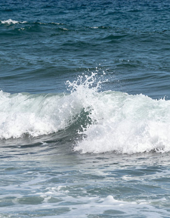 Wave breaking on the beach, close-up of a sea wave