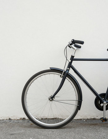 Bicycle leaning against a white wall, with copy space for textの写真素材