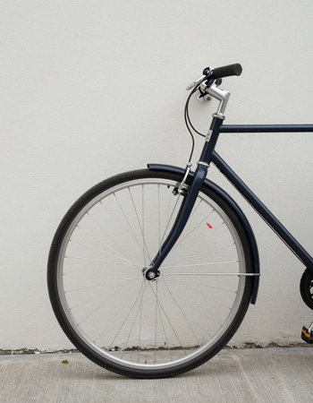 Bicycle on the floor in front of a wall with copy space