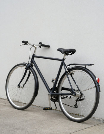 Bicycle parked in front of a white wall with space for text