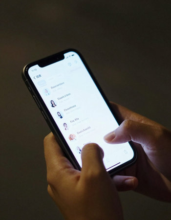 Woman hand holding smartphone with messenger app on the screen. It is one of the largest social...