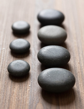 zen basalt stones on wooden background - beauty treatment and health care