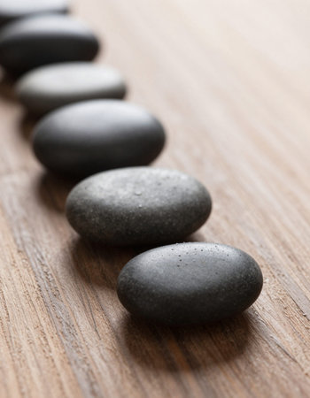 Spa stones on wooden background, closeup. Zen concept.
