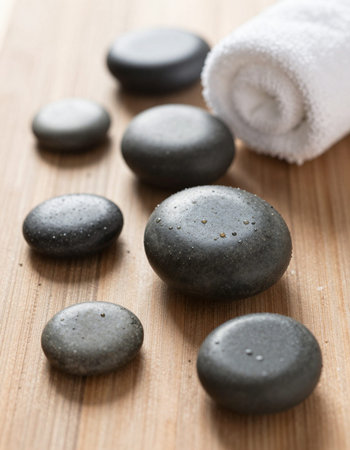 Spa stones and towel on wooden background, closeup. Zen concept