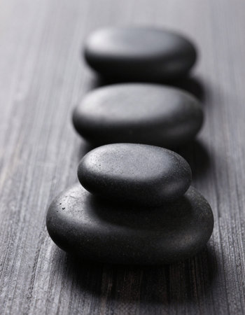 Spa stones on wooden table, closeup. Zen concept.