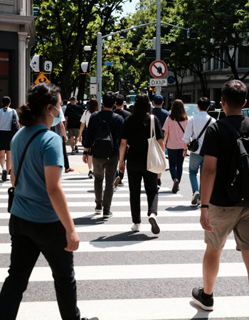 People crossing the street. The image depicts an urban scene with multiple pedestrians navigating a crosswalk.の写真素材