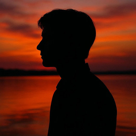 Silhouette of a man on a background of the setting sun