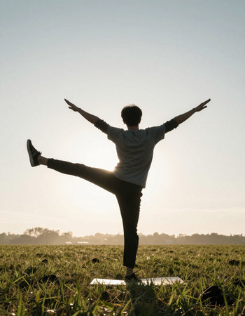 Young woman practicing yoga in the park at sunrise. Healthy lifestyle concept.