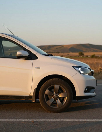 Side view of a white car on the side of a road.