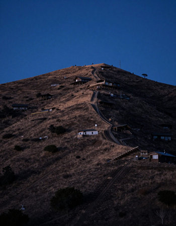 A view of the mountain at night from the top of a hill.