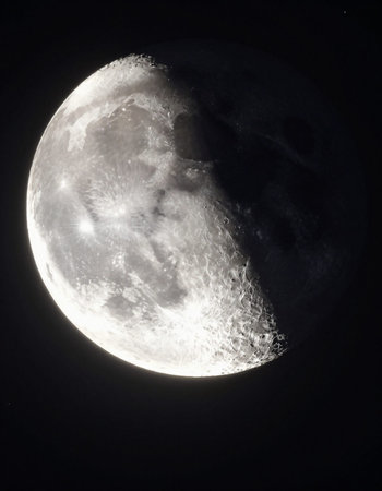 Full moon in the night sky, as seen from a telescope.