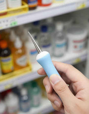 Close-up of a female hand holding a tool in a pharmacy