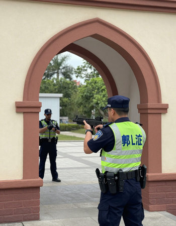 Policewoman in uniform with a gun at the entrance to the building