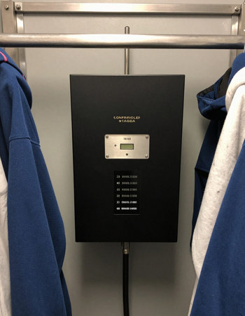 Hanging T-Shirts with a controller device mounted on the wall.の写真素材