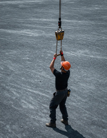 Construction worker at a construction site, lifting a heavy duty crane.