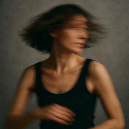 Young girl in a black tank top. Blurred background.