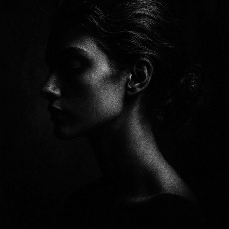Black and white portrait of a beautiful young woman in profile. Studio shot.