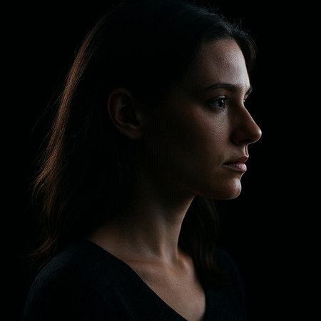 Portrait of a beautiful young woman on a black background in profile