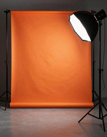 Photo studio with orange softbox and lighting equipment, on grey backgroundの写真素材