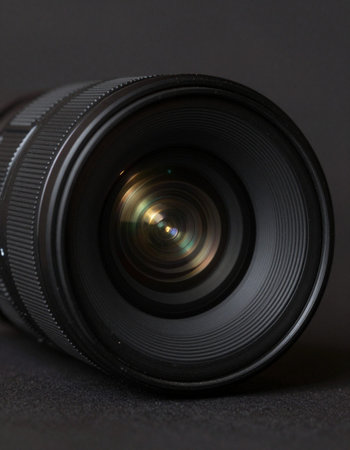 Camera lens on black background, close up. Shallow DOF