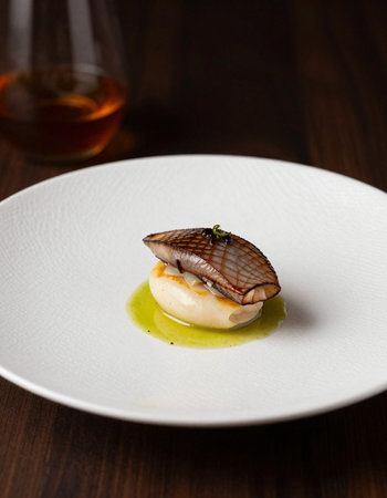 Grilled scallops on a white plate on a wooden table