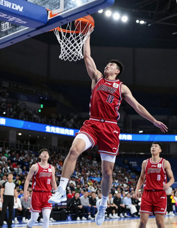 A basketball player, with ball, is on the attack during a game.