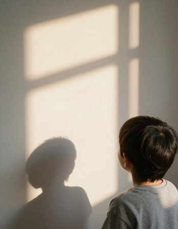 A child watching a shadow of the sun through the window.