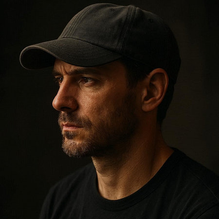 Portrait of a man on a dark background in a cap.