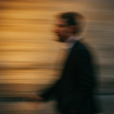 Businessman walking in the street with motion blur effect. Intentional motion blur