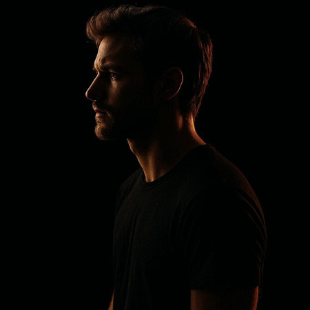 Portrait of a handsome young man in a black t-shirt on a black background