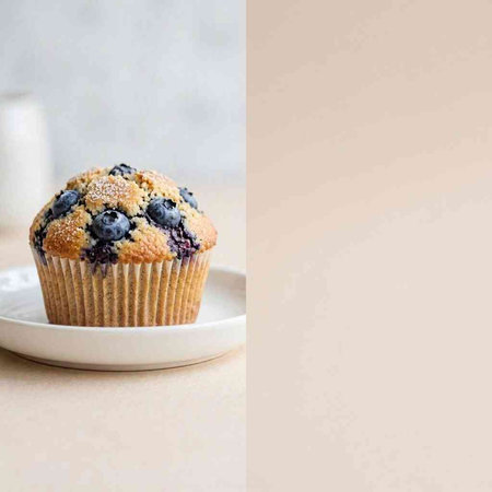 Blueberry muffin on white plate with copy space for text.