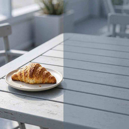 Croissant on a white plate on a wooden table in a cafe