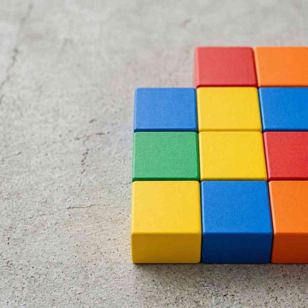 Colorful wooden building blocks on concrete background. Selective focus.