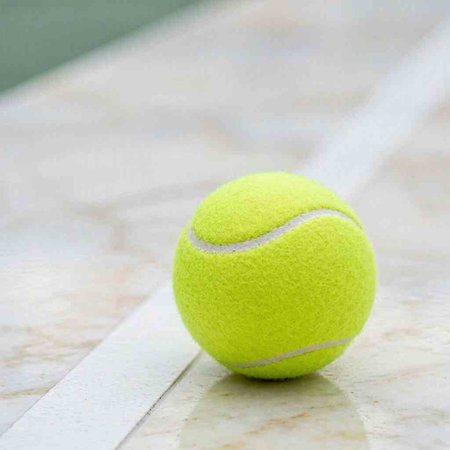 Tennis ball on a tennis court. Selective focus on the ball.