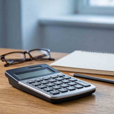Calculator and eyeglasses on a wooden table with notebook