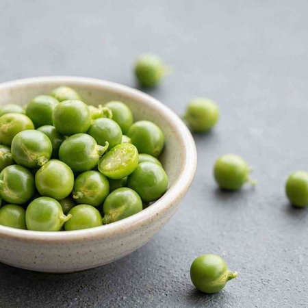 Bowl of fresh green peas on grey background, selective focus.