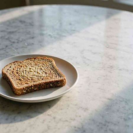 A slice of bread on a white plate on a marble table.