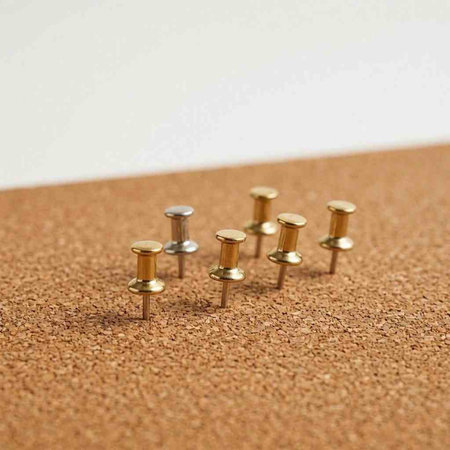 A group of pushpins on a cork board. Selective focus.