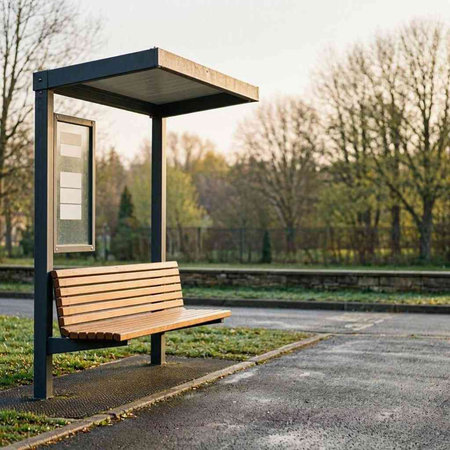 Bench in a public park with a bus stop in the background.